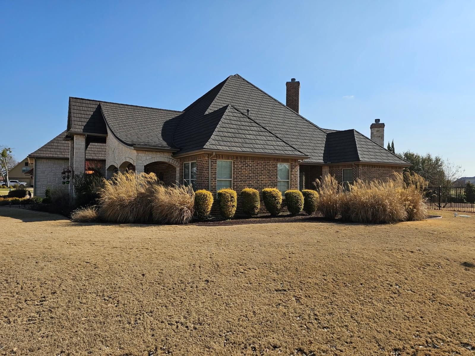 A large estate home with a charcoal WeatherLok stone-coated steel shake roof
